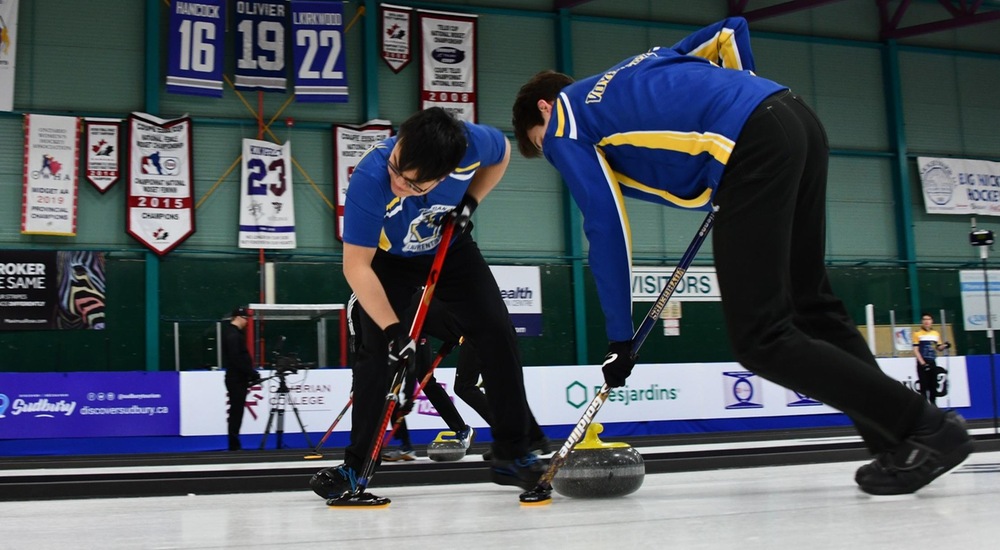 Leung and Bonin-Ducharme sweeping a stone - Curling Canada/Duncan Bell